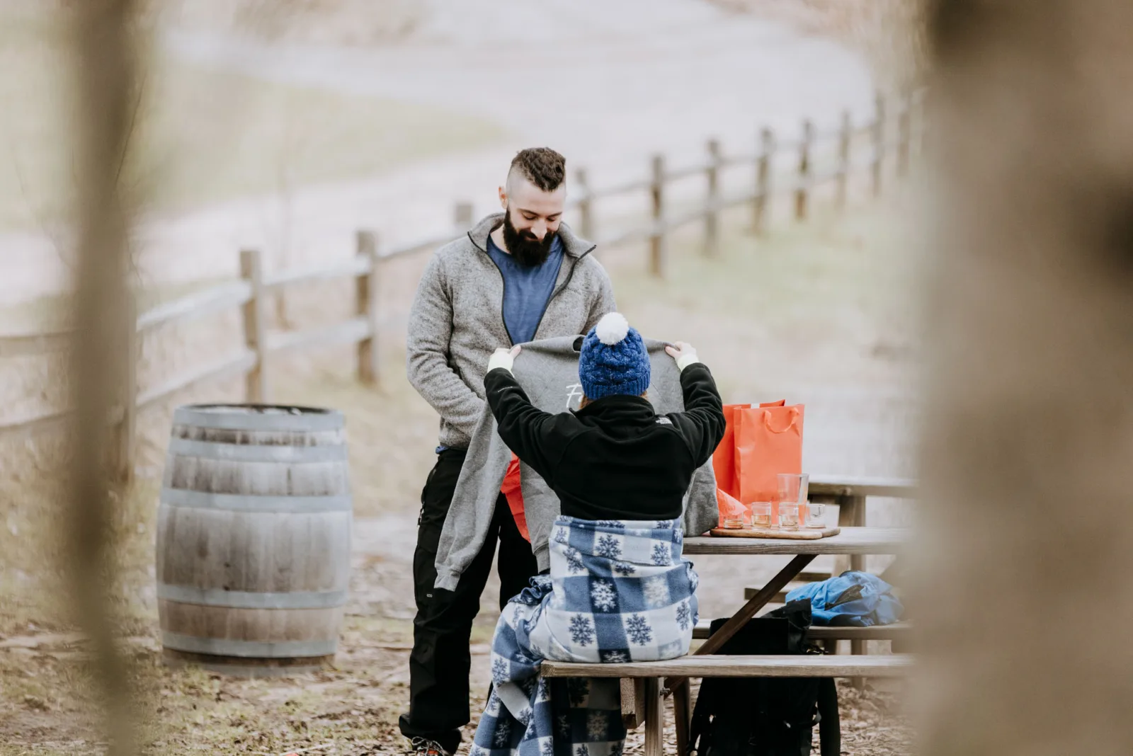 Karl helping Tiffa put on a custom Tandem Ciders sweatshirt just before the proposal
