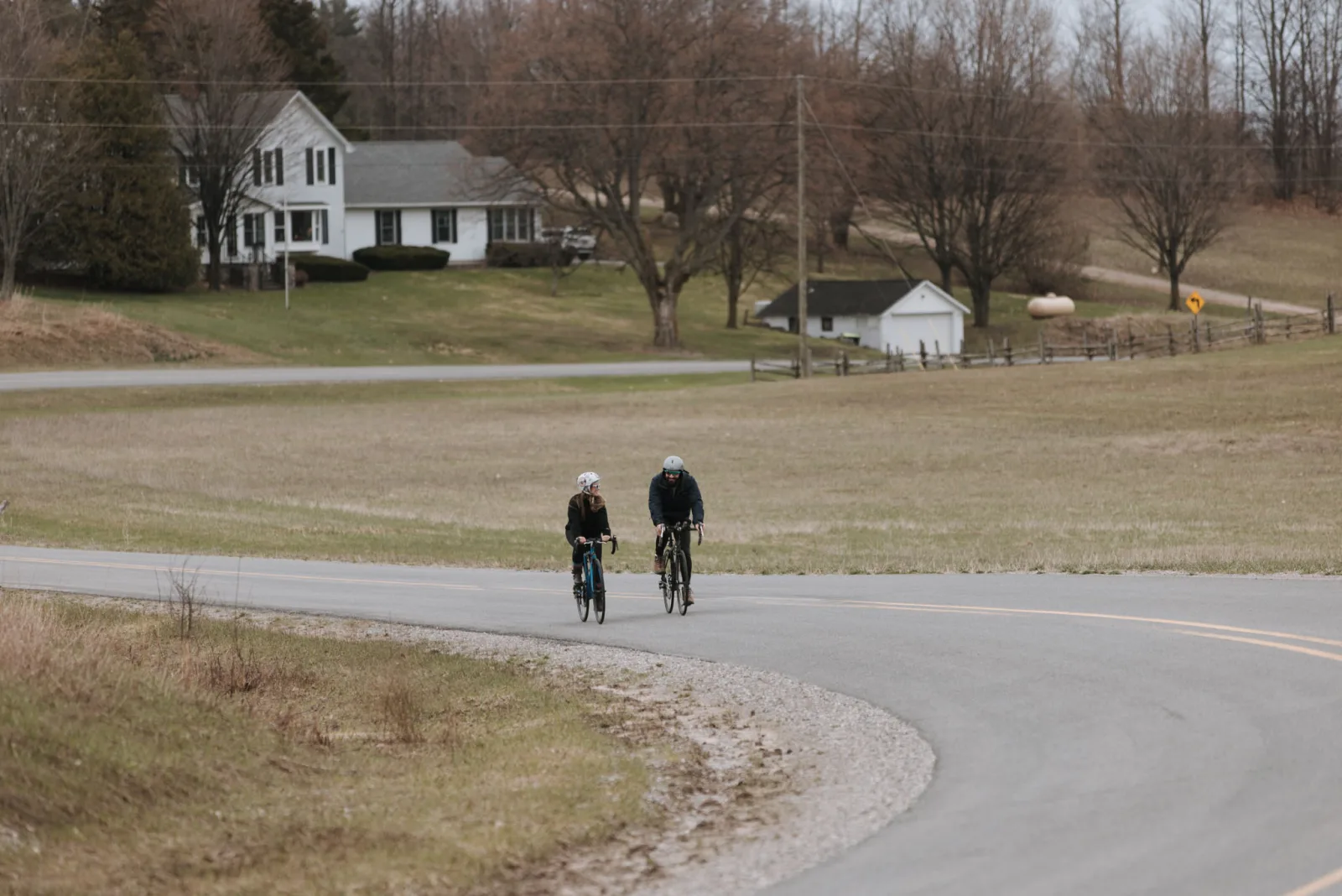 Tiffa and Karl riding bikes along a rural road near Tandem Ciders in Suttons Bay