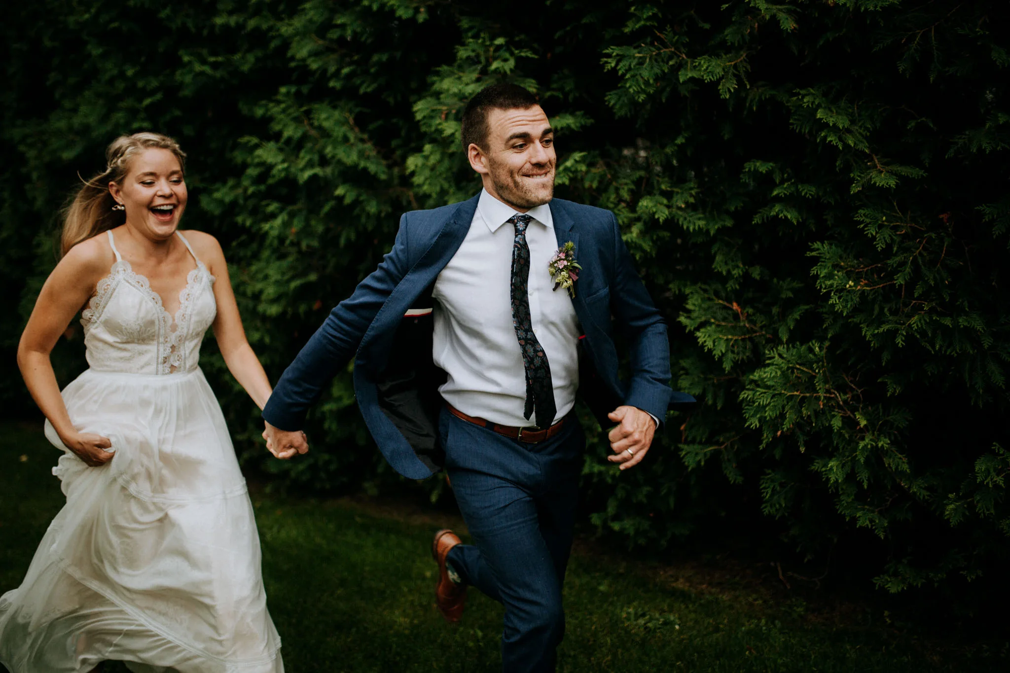 Bride leaning on groom during beach portraits in Leland Michigan