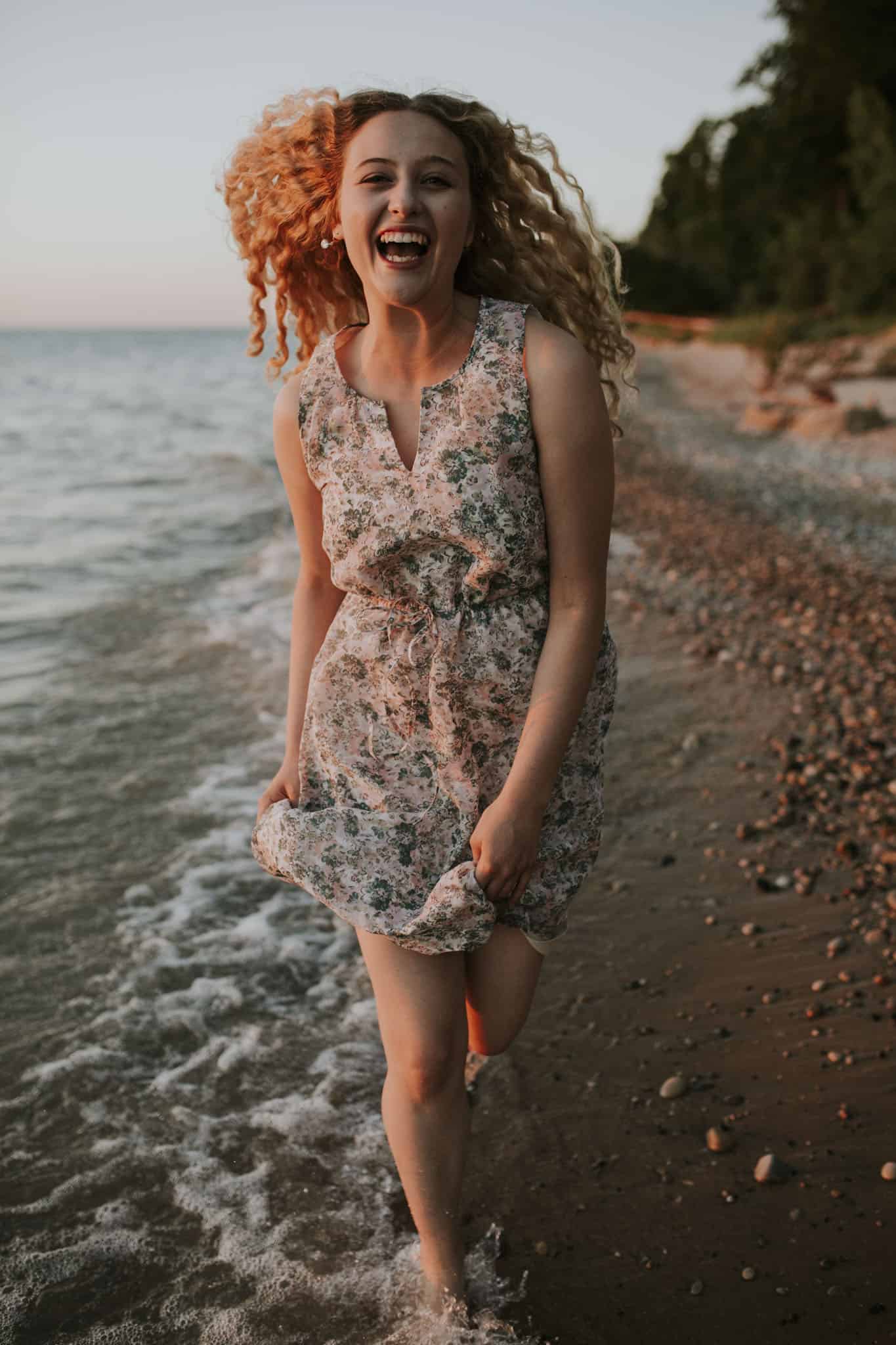 girl running on a beach in northern michigan at sunset