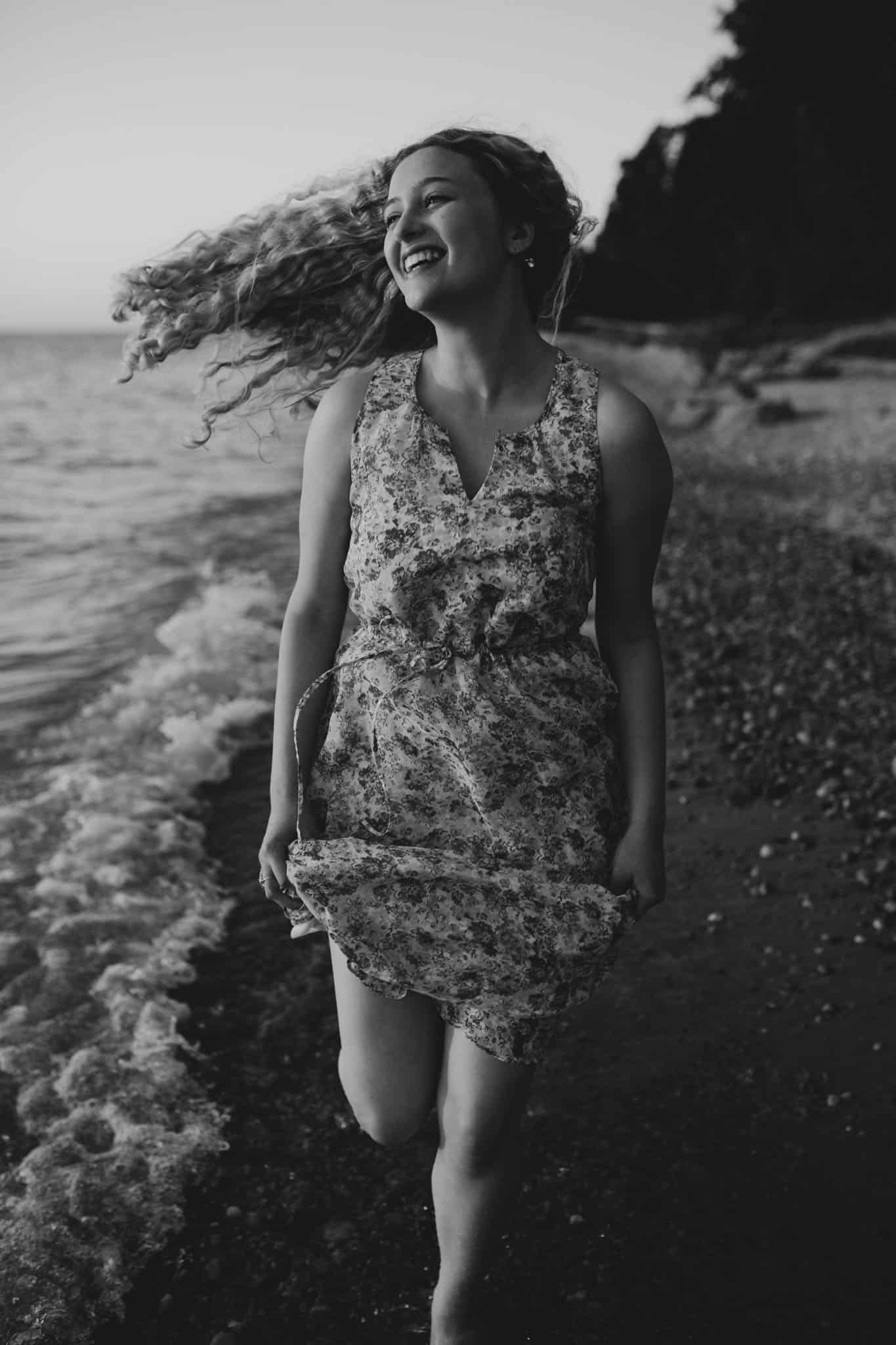 black and white photo of a girl running on a beach in northern michigan at sunset