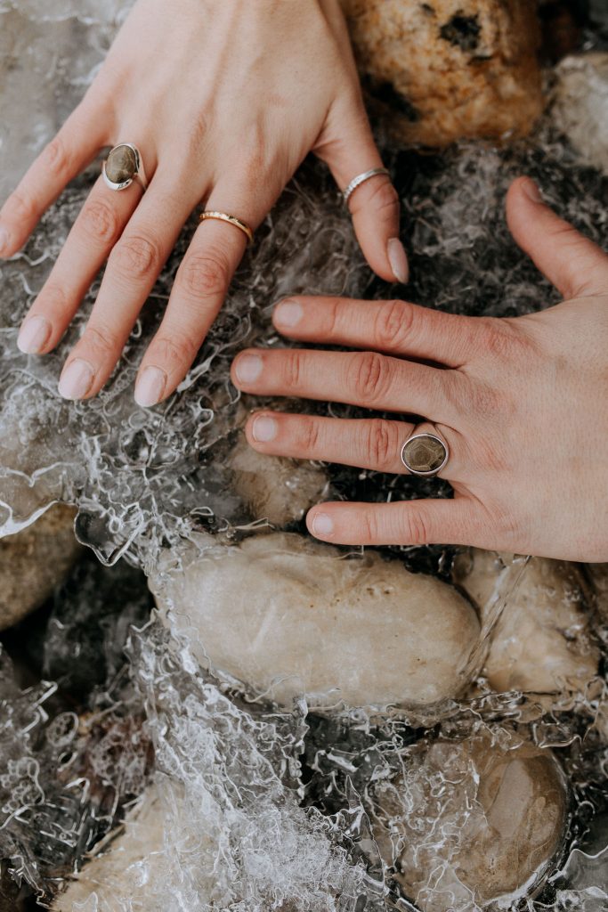 winter traverse city elopement couple with Petoskey stone rings over lake Michigan ice