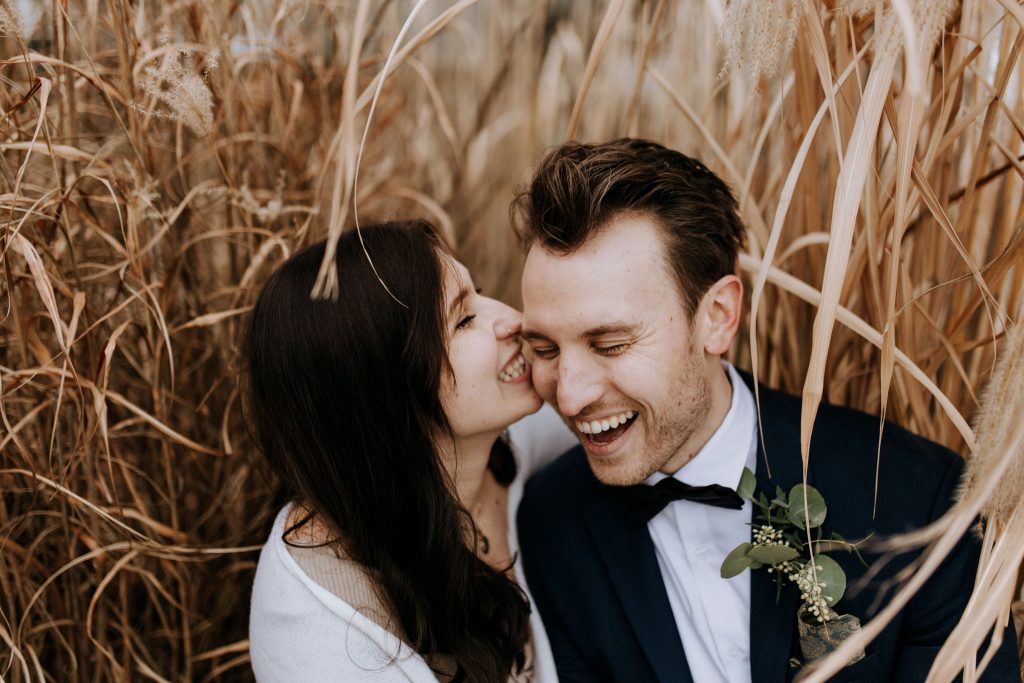winter traverse city elopement Couple Sitting in reeds