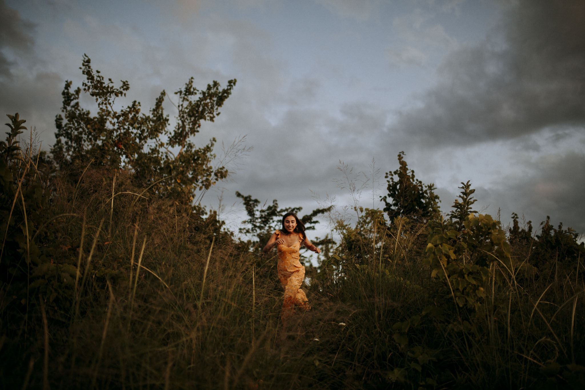 Senior running down the dunes in the dune grass