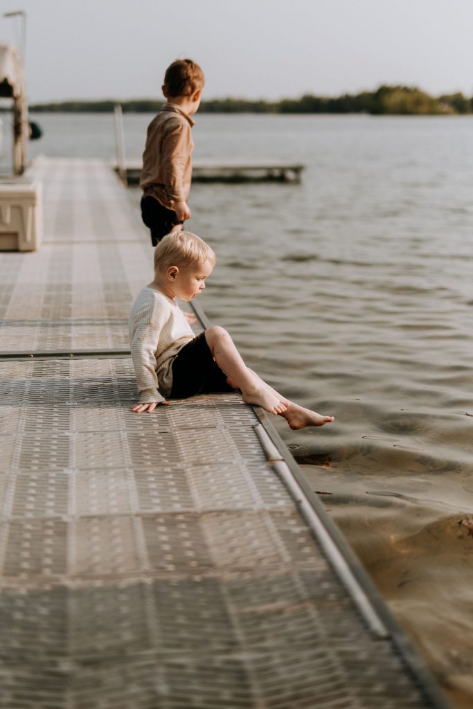 kid sitting on a dock at a traverse city beach